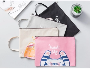 Detail of four colorful cartoon cat document bags with handles and zipper closures