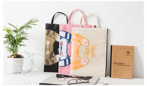 Close-up of four canvas document bags with cute cat illustrations and zipper closure