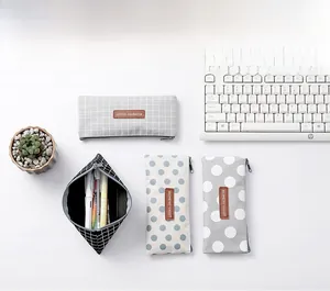 Minimalist canvas pencil case with grid patterns and metal zipper in a workspace setting