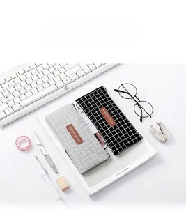Minimalist grid pattern fabric pencil case shown with office stationery on a white desk