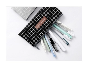 Detail showing the black and white checkered pencil case with leather logo and pens