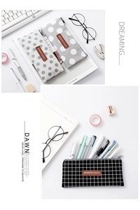 Detail of canvas pencil cases with polka dots and grid patterns on a minimalist desk