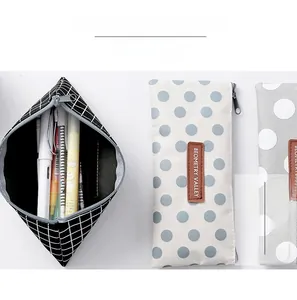 Detail showing high capacity storage of black plaid and polka dot canvas pencil cases