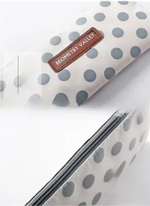 Detail van een duurzame canvas pennenzak met grijze stippen en een leren label
