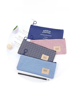 Detail of four colorful striped canvas pencil cases with large ring zipper pulls