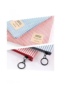 Detail of striped canvas pencil case featuring a metal ring zipper and fabric label