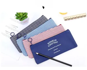 Detail of colorful striped oxford cloth pencil cases with circular metal zippers