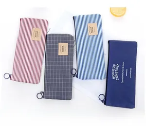 Detail of four striped oxford cloth pencil pouches with circular ring zippers and leather tags