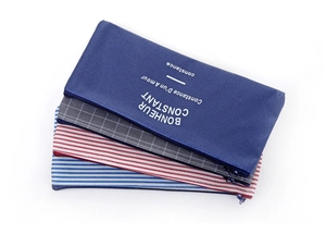 Detail of four colorful striped and checkered canvas pencil cases with zipper closures