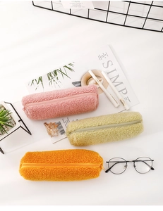 Detailed view of plush lamb wool pencil cases in pink, green, and orange with zipper