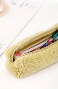 Close-up of soft yellow plush pencil case with zipper and cat paw stationery inside