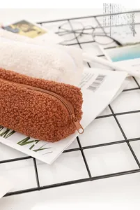 Close-up of soft sherpa fleece pencil cases with smooth zippers in beige and brown colors