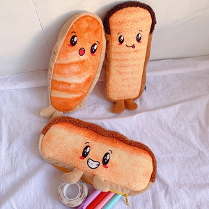 Three cute toast plush pencil cases with cartoon faces and 3D feet shown on a cloth
