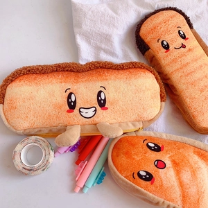 Detailed view of plush bread-shaped pencil cases with cute faces holding stationery on a desk