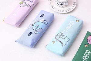 Close-up of canvas pencil cases with cartoon dinosaur prints in four pastel colors