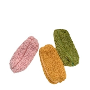 Three lamb wool pencil cases in pink, yellow and green on a clean white background