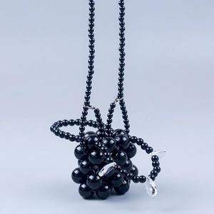 Detail van handgemaakte zwarte kralen handtas met kristallen diamant hangers