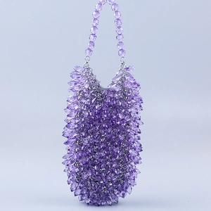 Detalle de bolso de cuentas moradas con texturas de gotas de agua de cristal acrílico
