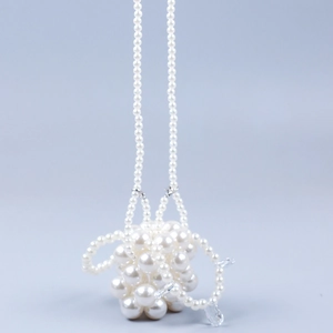 Detail van witte parelhanger met kristallen voor modieuze mini-handtassen