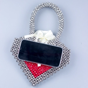 Handmade beaded heart-shaped handbag with silver beads and a red heart pattern