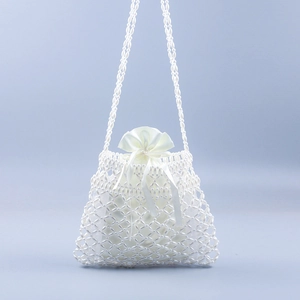 Detail of elegant white pearl beaded crossbody bag with a white satin drawstring pouch