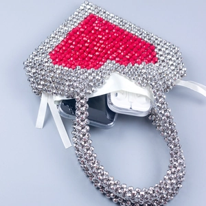 Detailed interior of heart beaded bag showing capacity for phone and wireless earbuds