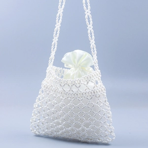 Detail of white handmade pearl crossbody bag featuring woven mesh and satin drawstring lining