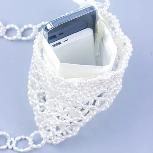 Elegant white pearl woven crossbody bag with satin pouch interior and mesh beaded structure