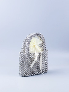 Detail der silbernen Perlenhandtasche mit facettierten Perlen und cremefarbenem Satinbeutel