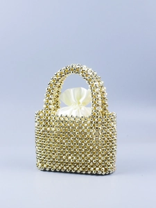 Nahaufnahme der goldenen Perlenhandtasche mit weißem Satin-Innenfutter und feinen Details