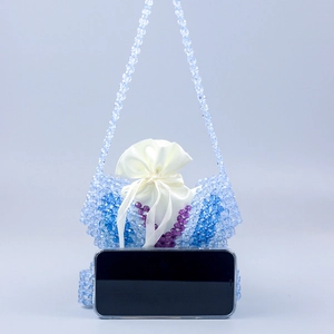 Detail of beaded shoulder bag with satin liner and smartphone for size reference