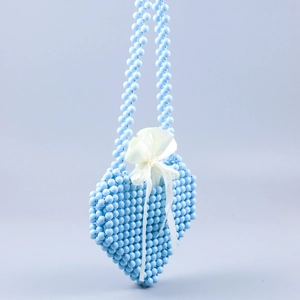 Detail of light blue beaded heart bag with white satin drawstring and ribbon bow