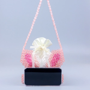 Pink handmade beaded mini bag with satin drawstring pouch compared to a smartphone