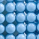 Macro shot of light blue hand-woven beads showing the intricate grid pattern of the bag