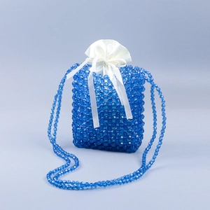Detailed view of handmade blue beaded shoulder bag with white satin drawstring inner pouch