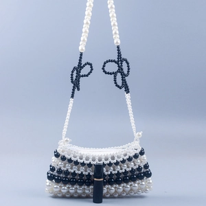 Handmade black and white pearl beaded handbag with bows and lipstick for size reference