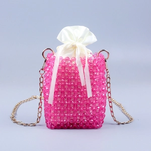 Detailed shot of pink beaded bag featuring a white satin drawstring pouch and gold chain