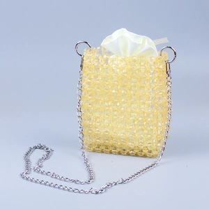Detail of handcrafted yellow beaded crossbody bag with silver chain and satin inner pouch