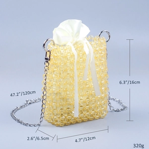 Detail of cream handmade beaded mini bag with satin pouch and silver chain strap
