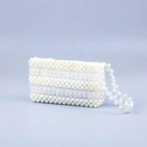 Détail de la pochette perlée à la main avec perles en acrylique blanches et transparentes