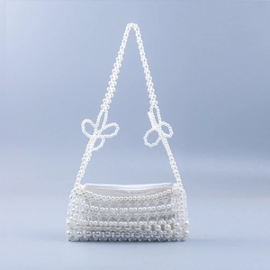 Detail of handmade pearl beaded bag with zip closure and elegant pearl bow on the strap