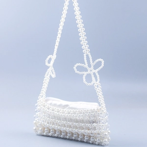 Handmade pearl beaded shoulder bag with white bow accents and satin lining detail