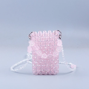 Pink handmade beaded mini crossbody bag with heart strap on a soft blue background