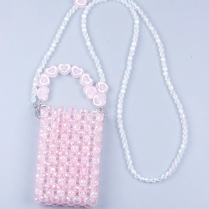 Macro view of pink beaded crossbody bag with heart-shaped handle and translucent beads