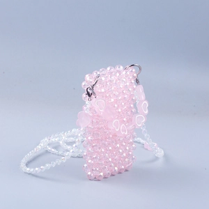 Detail of pink handmade beaded mini bag with heart charms and crystal-like woven beads