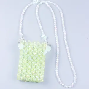 Detail of light green beaded crossbody bag with white heart charms and pearly strap