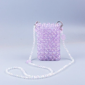 Detail view of purple hand-woven beaded crossbody bag with glossy acrylic heart pendant