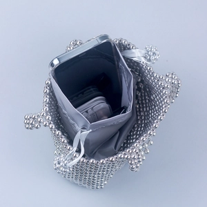 Sac seau perlé argenté avec doublure à cordon montrant un intérieur pour smartphone