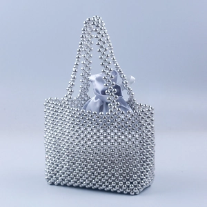 Détail du sac à main en perles argentées fait main avec pochette en satin et perles métal