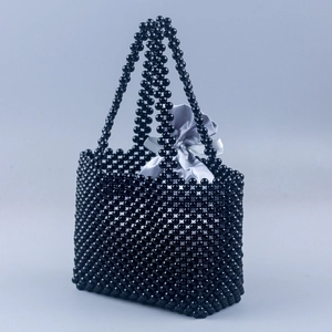 Détail du sac à main tissé à la main en perles noires avec doublure en satin gris